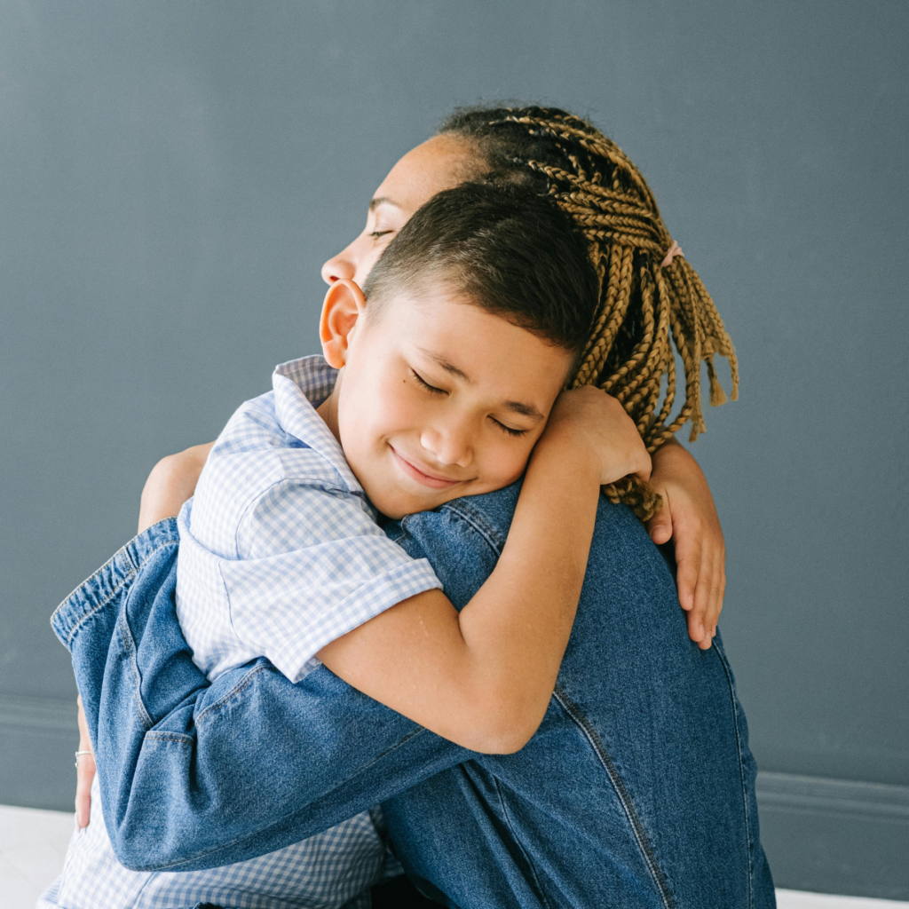 In this image, a boy hugs his mom.